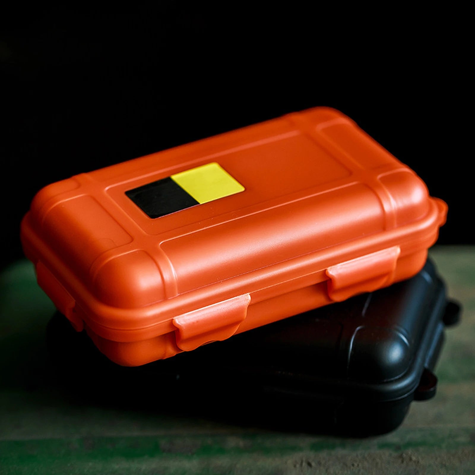 Orange and black fidget toy storage cases stacked on a dark surface