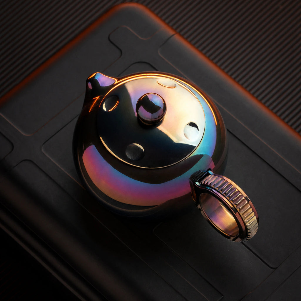 Heat-colored ratchet fidget toy with toothed ring handle in top view