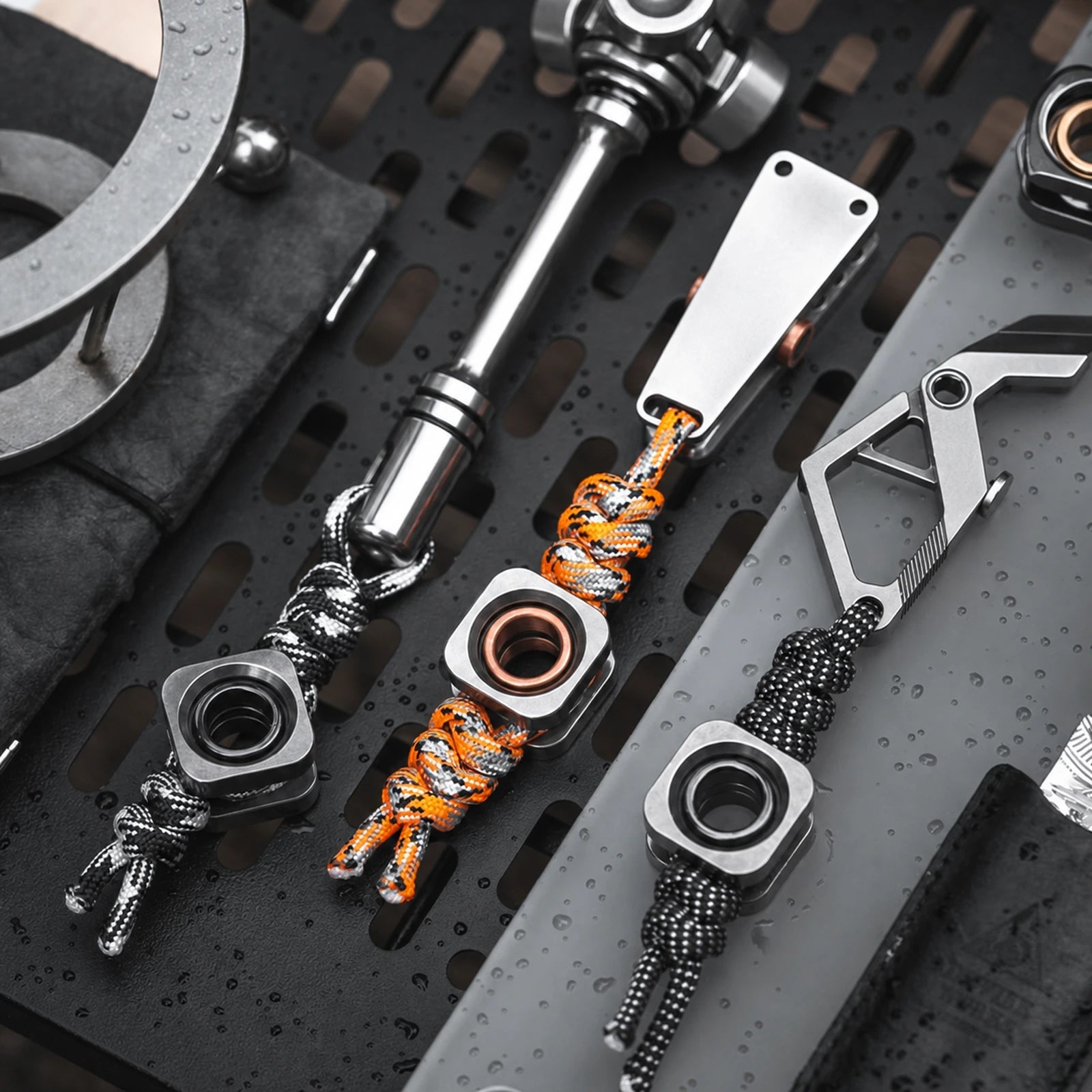 Three square lanyard beads with black and orange paracord arrangements